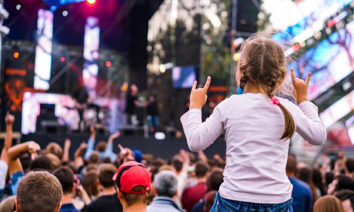 Kind das auf den Schultern des Vaters einem Konzert lauscht 