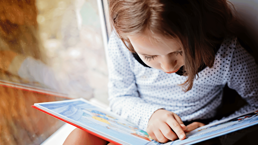 Kind das im Wald sitzt und liest